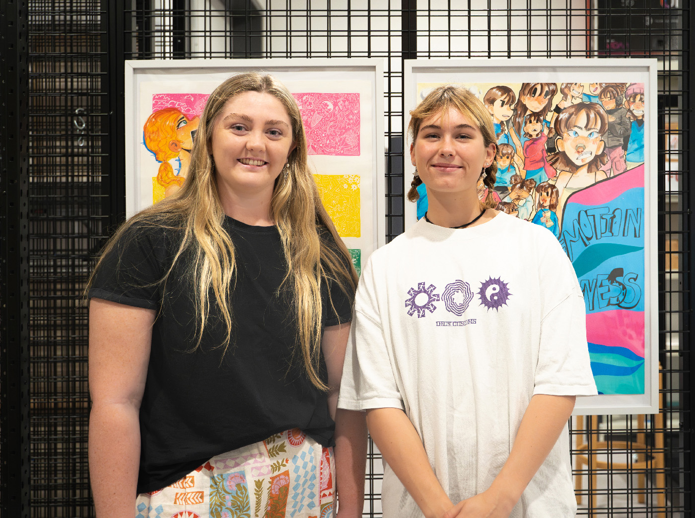 A portrait of young students Brydi Ann Custance and Indy Leet standing in front of their artwork.